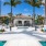 a swimming pool with palm trees and a building in the background