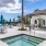 a pool with chairs and umbrellas by a building